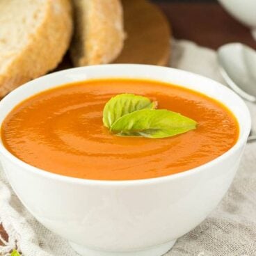 Slow Cooker Creamy Tomato Soup: Tomatoes and vegetables simmer away all day until tender, then they're pureed to make this ultra creamy, vibrant tomato soup that is secretly loaded with veggies! Your kids will never know! www.thereciperebel.com