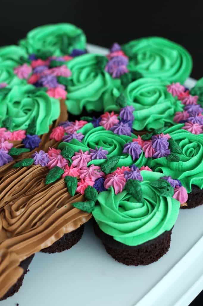 close up image of cupcake cake with flowers and leaves