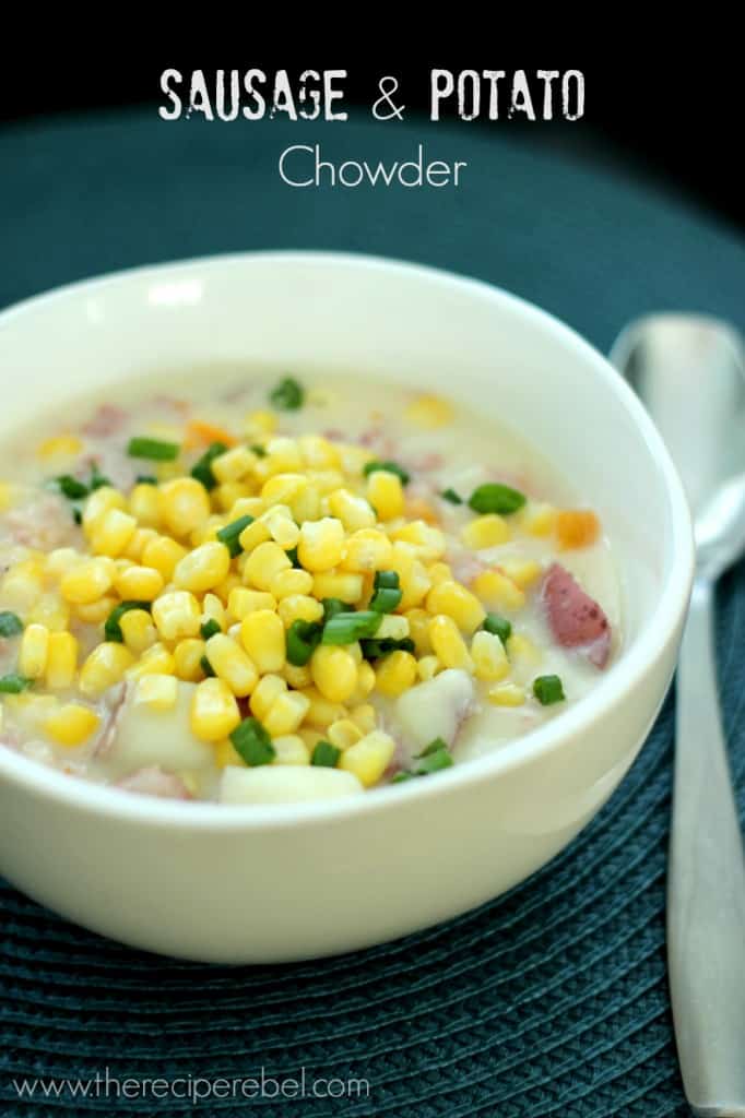 sausage potato chowder in white bowl with corn and green onion on top