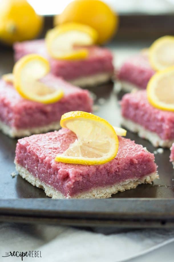 squares of strawberry pineapple lemonade bars on baking sheet topped with lemon slices