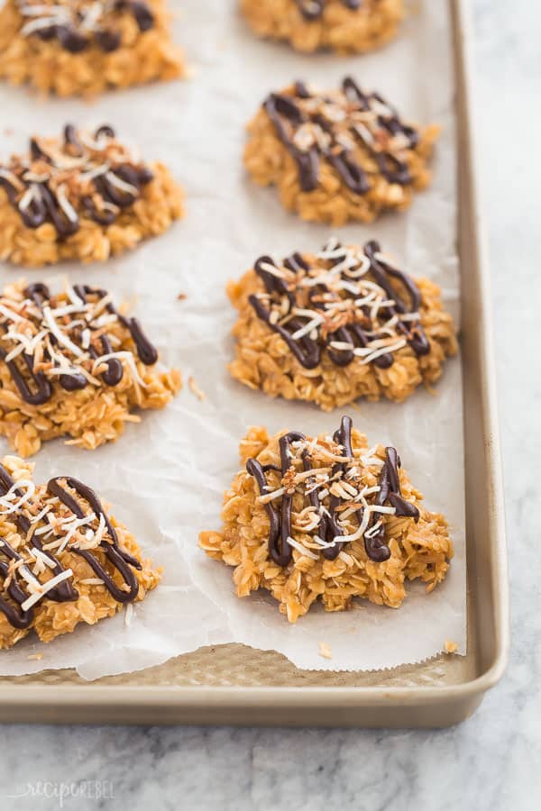 No bake cookies made with butterscotch pudding, oats and coconut, topped with melted chocolate and toasted coconut: all the flavors of a Samoa cookie but so much easier! #cookies #recipe #dessert #cookie #chocolate no bake samoa cookies on pan with parchment paper