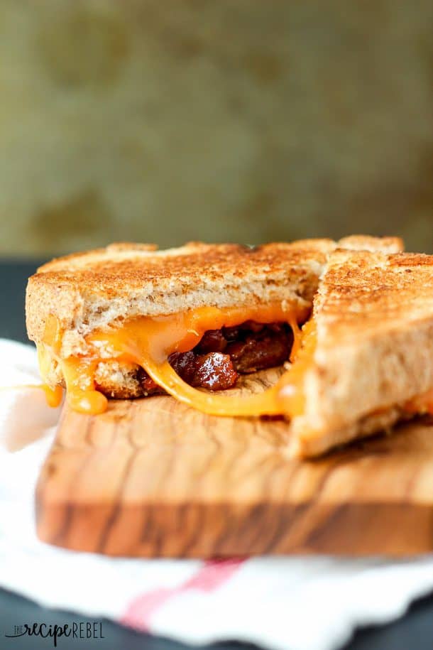 bacon jam grilled cheese cut open on wooden cutting board