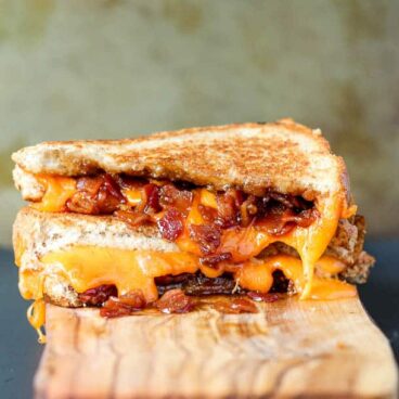 Toasty bread, melty cheese and sweet and smoky maple bacon jam make this the best grilled cheese you'll ever have! www.thereciperebel.com