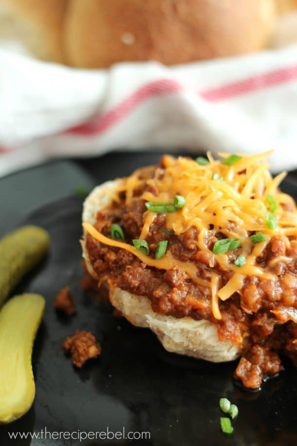 ground beef crock pot lentil sloppy joes topped with shredded cheddar cheese and pickles on the side