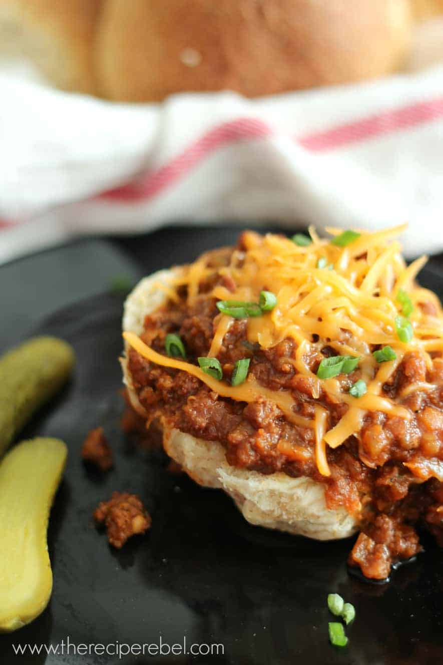 beef and lentil sloppy joes on half bun with shredded cheese and sliced green onion