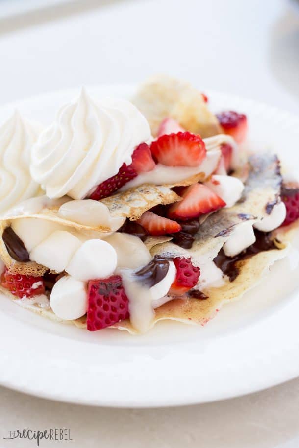 crepes folded with strawberries chocolate marshmallows and drizzled in custard sauce