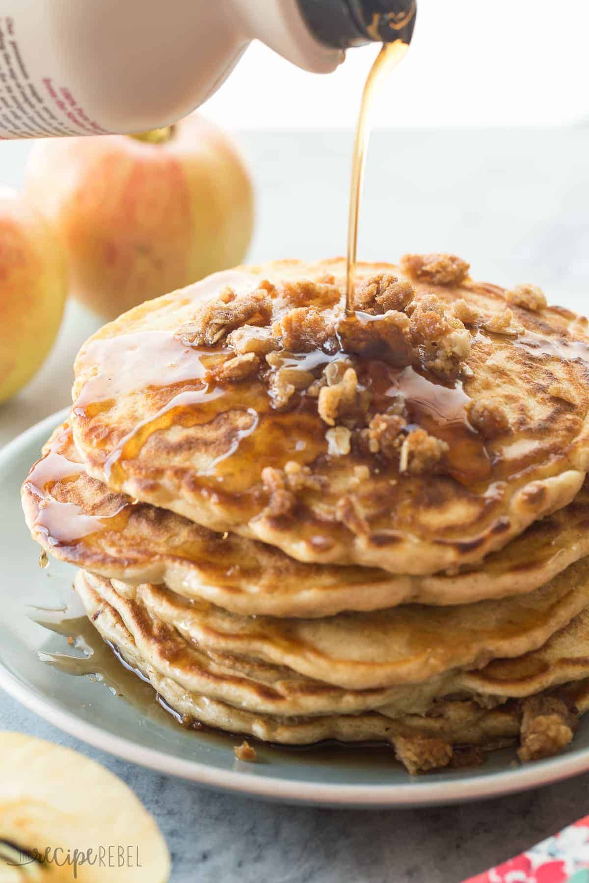 stack of pancakes with streusel crumbles on down and drizzle of syrup