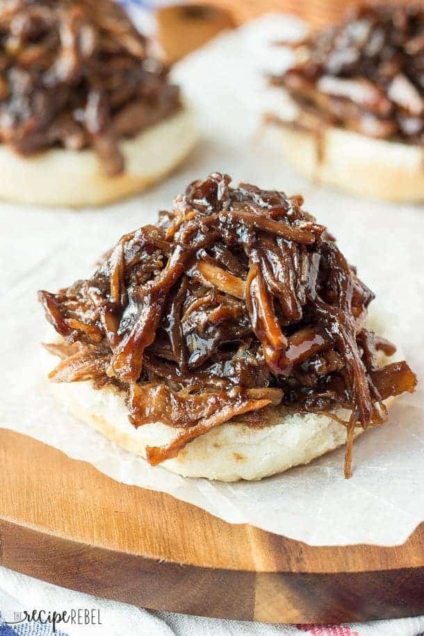 slow cooker honey balsamic pulled pork on a bottom bun on parchment paper