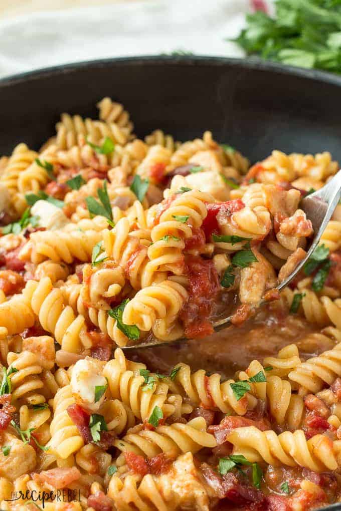 one pot bbq chicken pasta close up in pan with spoon scooping some up