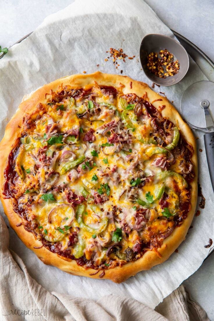 This BBQ Philly Cheesesteak Pizza is made with homemade pizza dough, bbq sauce, thinly sliced beef, sauteed peppers and onions and topped with cheese! It's a fun way to change up pizza night! #pizza #recipes | dinner ideas | pizza recipes | roast beef | easy dinner ideas overhead image of full philly cheesteak pizza