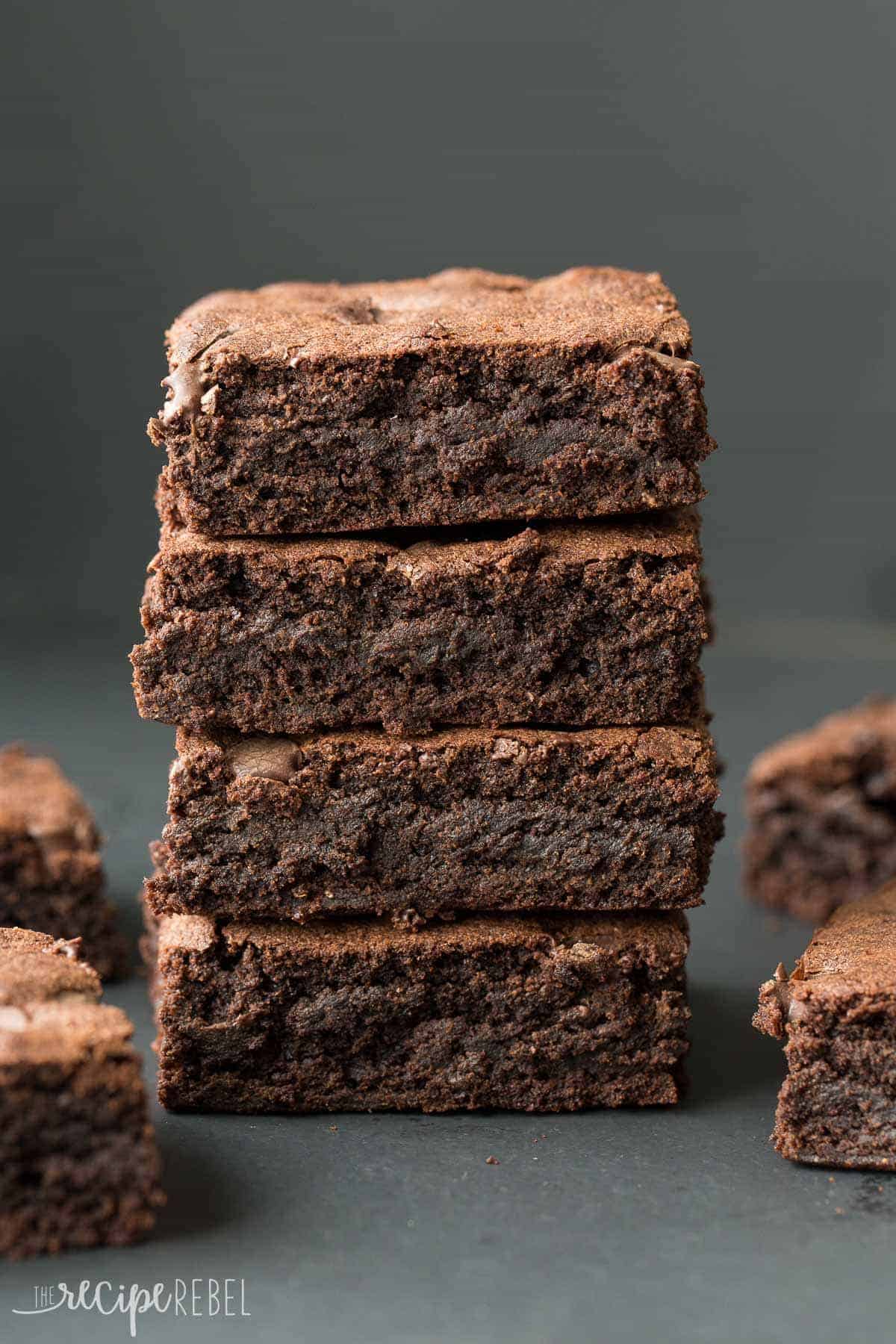 stack of four fudgy brownies on a black background