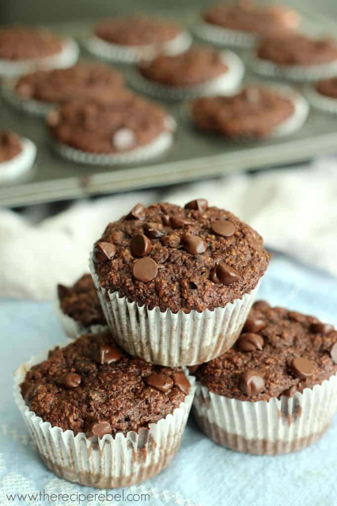 four chocolate banana bran muffins stacked with chocolate chips on top