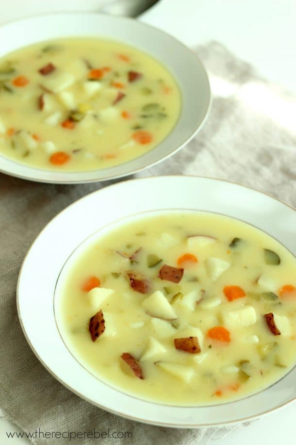 two white bowls with dill pickle soup on grey towel