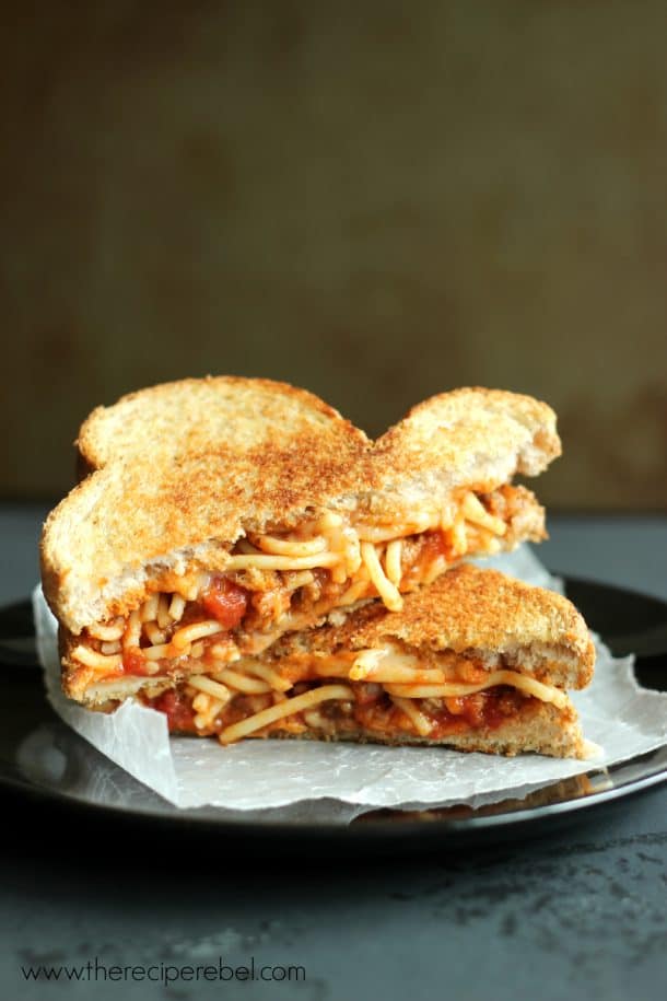 spaghetti and garlic toast grilled cheese stacked on black plate