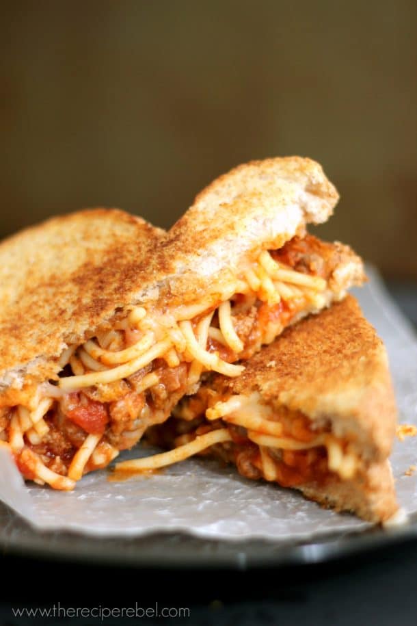 spaghetti grilled cheese cut in half and stacked on black plate