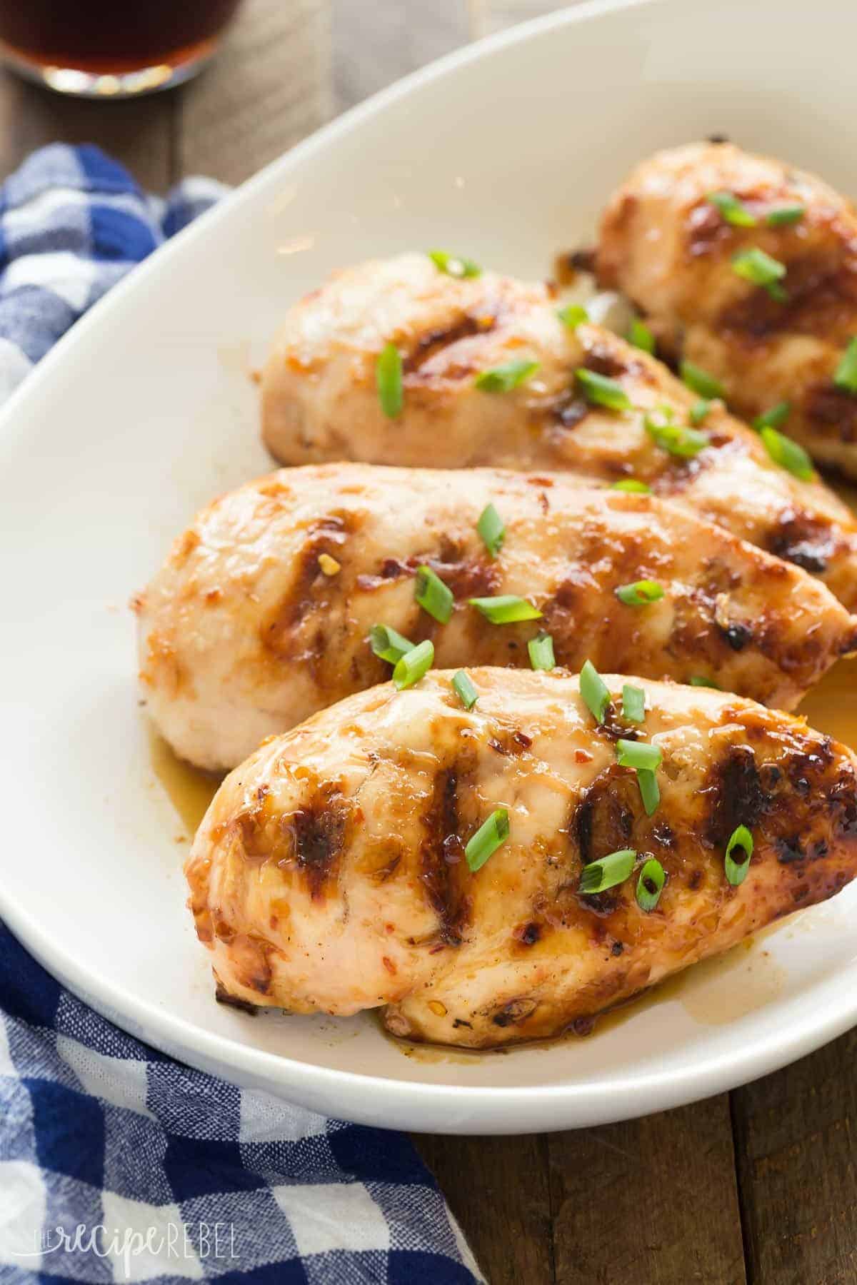 coconut grilled chicken on white plate with blue checked napkin on the side