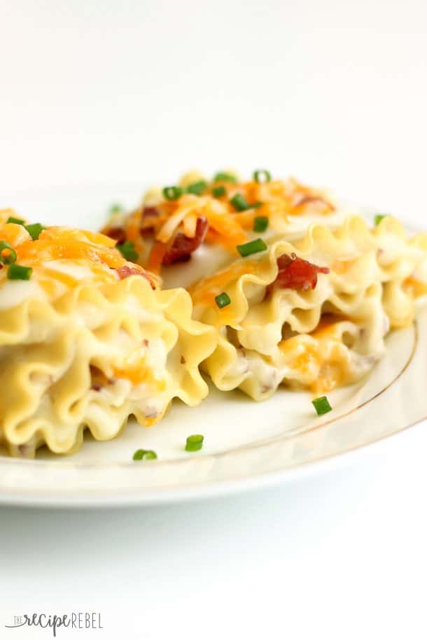 lasagna noodles rolled up with mashed potatoes and cheese and topped with bacon and chives