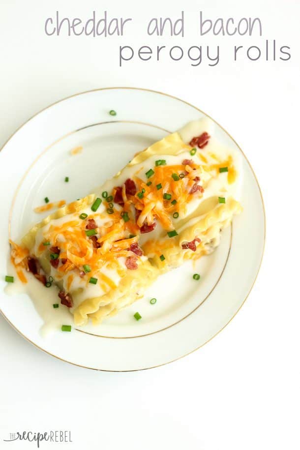 overhead image of a plate with two perogy rolls topped with cheddar cheese bacon and green onions