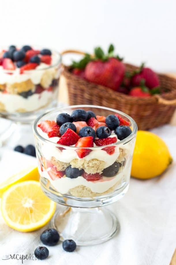 small glass bowl with vanilla cake cubes fresh berries lemon curd and whipped cream