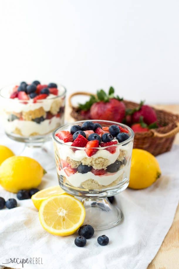 two small glass bowls with layers of lemon berry cheesecake trifles