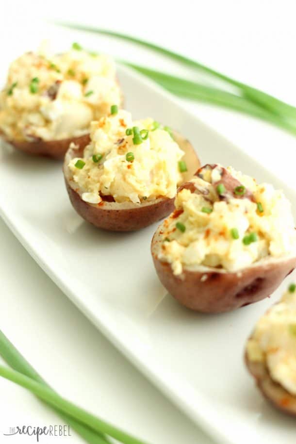 potato salad bites on white plate topped with green onions