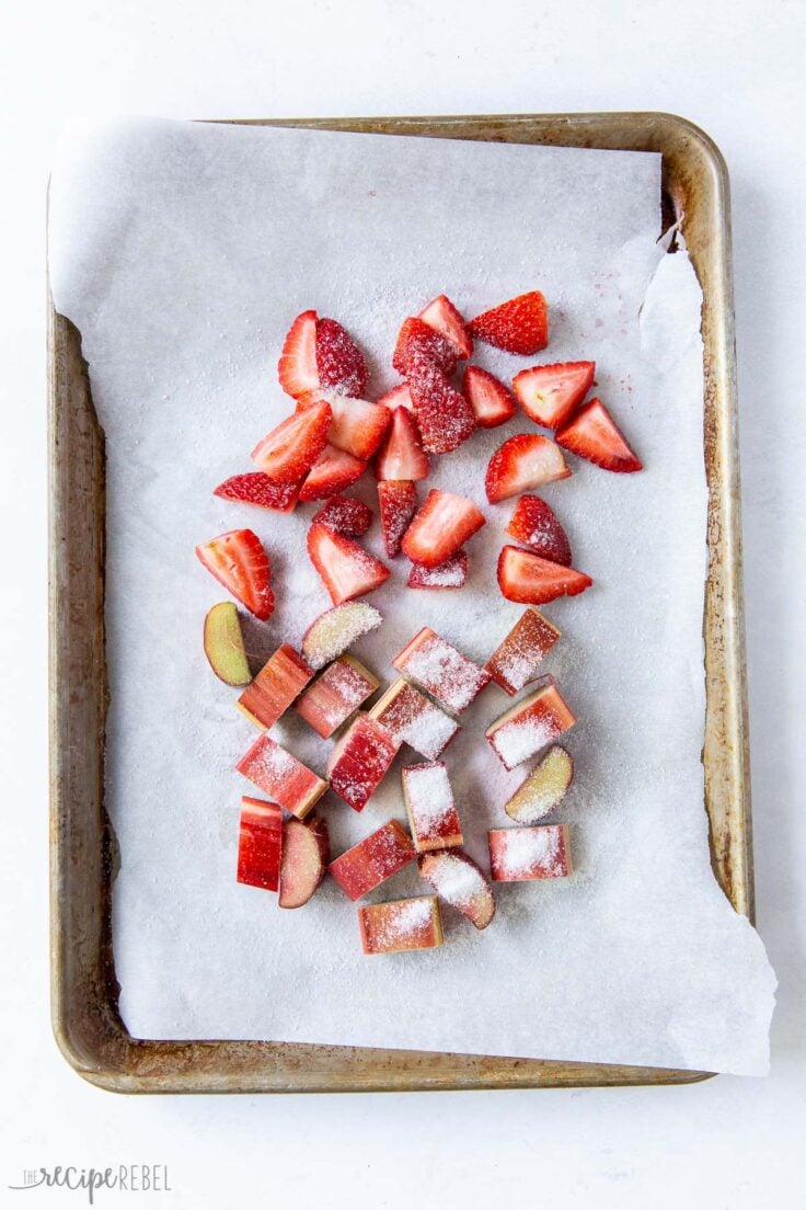 strawberries and rhubarb on baking sheet with parchment