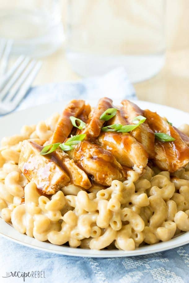close up image of bbq chicken mac and cheese on white plate with blue towel underneath