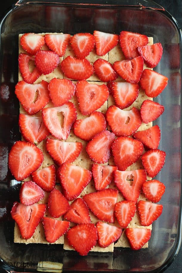 glass baking dish lined with whole graham crackers and topped with sliced strawberries