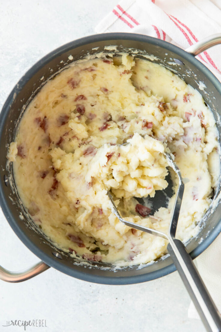 potatoes being mashed in pot