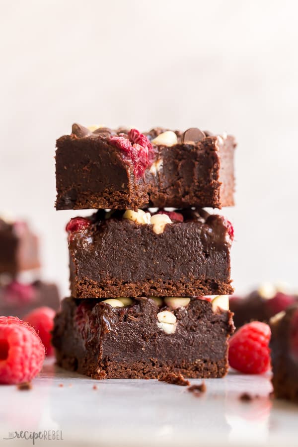 stack of three triple chocolate raspberry brownies with one bite taken 