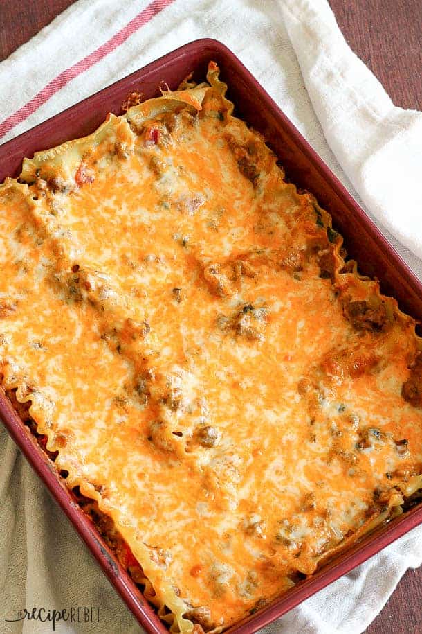 overhead image of creamy chipotle italian sausage lasagna in red baking dish