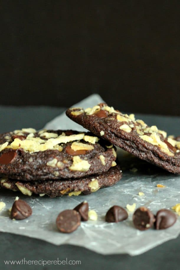 3 chocolate potato chip cookies stacked on parchment paper