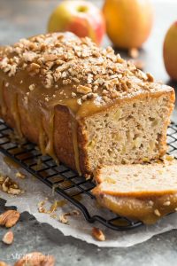 This Praline Glazed Apple Bread is so moist and decadent! It's loaded with apples and covered in an easy caramel glaze and chopped pecans -- perfect for fall or Thanksgiving baking! Includes step by step recipe video. | fall baking | thanksgiving brunch | breakfast | caramel | pecan | easy | apple picking | christmas | holiday
