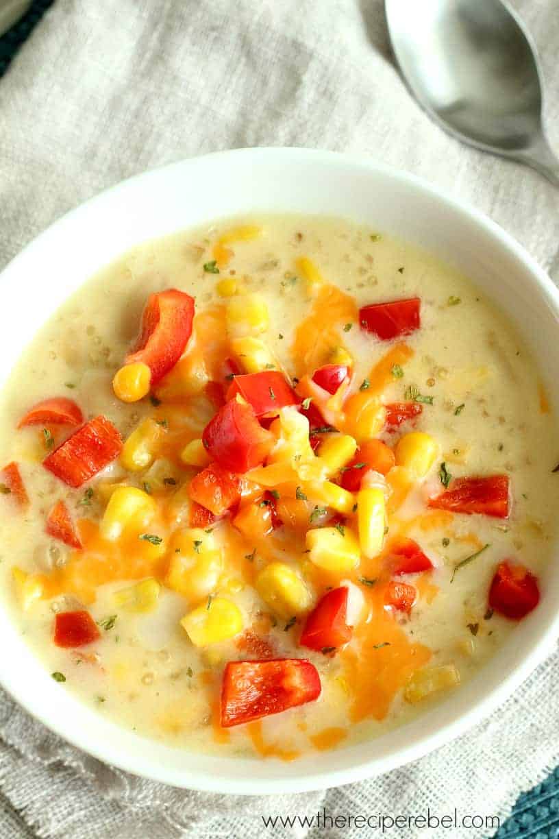 quinoa corn chowder in white bowl topped with red peppers and corn