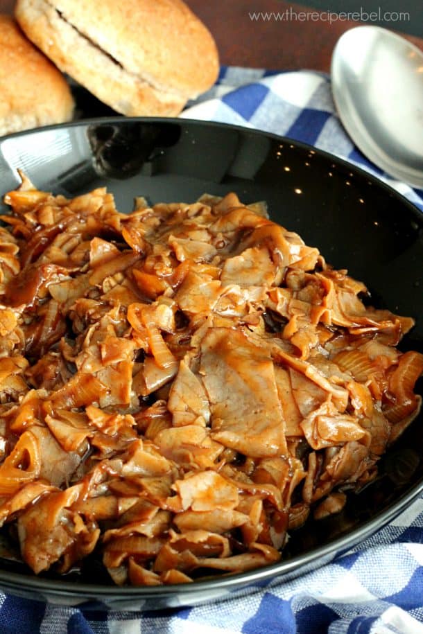 close up of shredded barbecue beef in large black serving bowl
