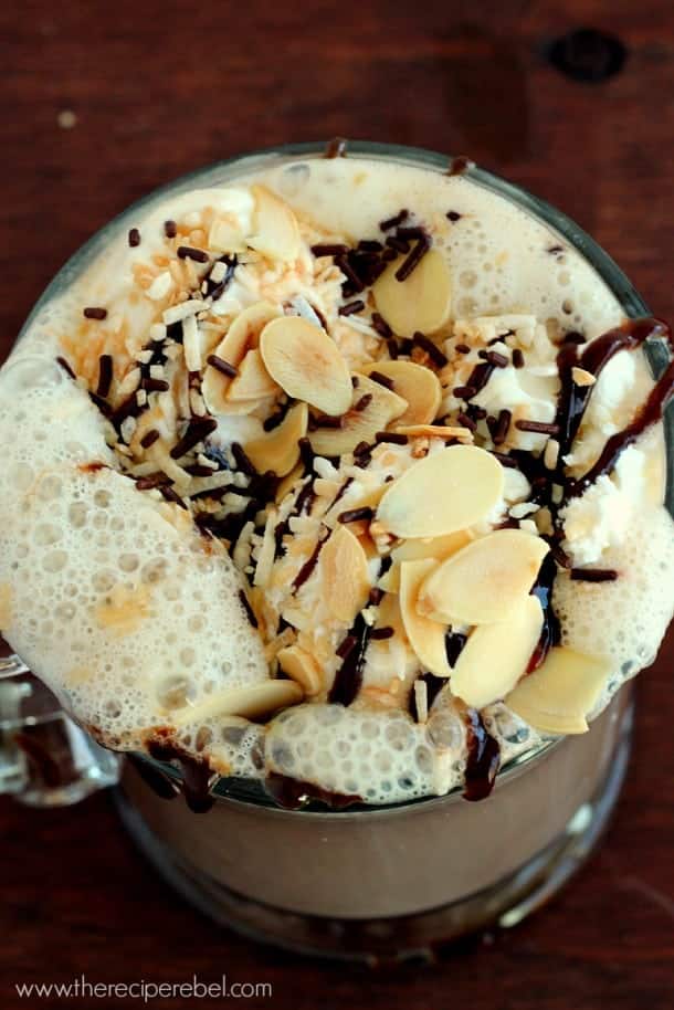 overhead image of mug with whipped cream almonds and chocolate sauce