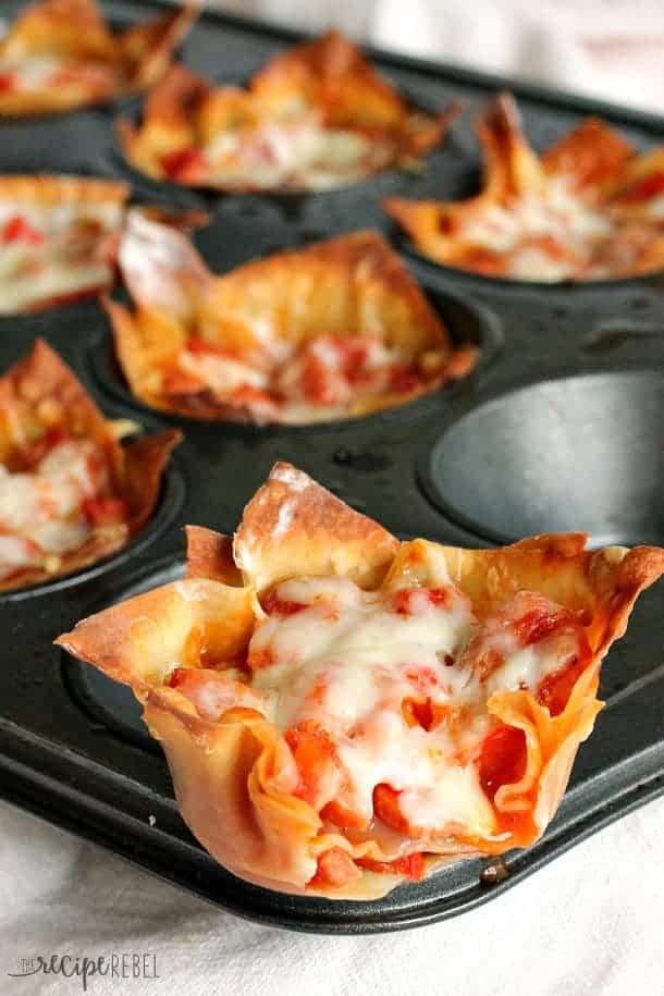 close up of pepperoni pizza cupcake sitting on the edge of muffin pan