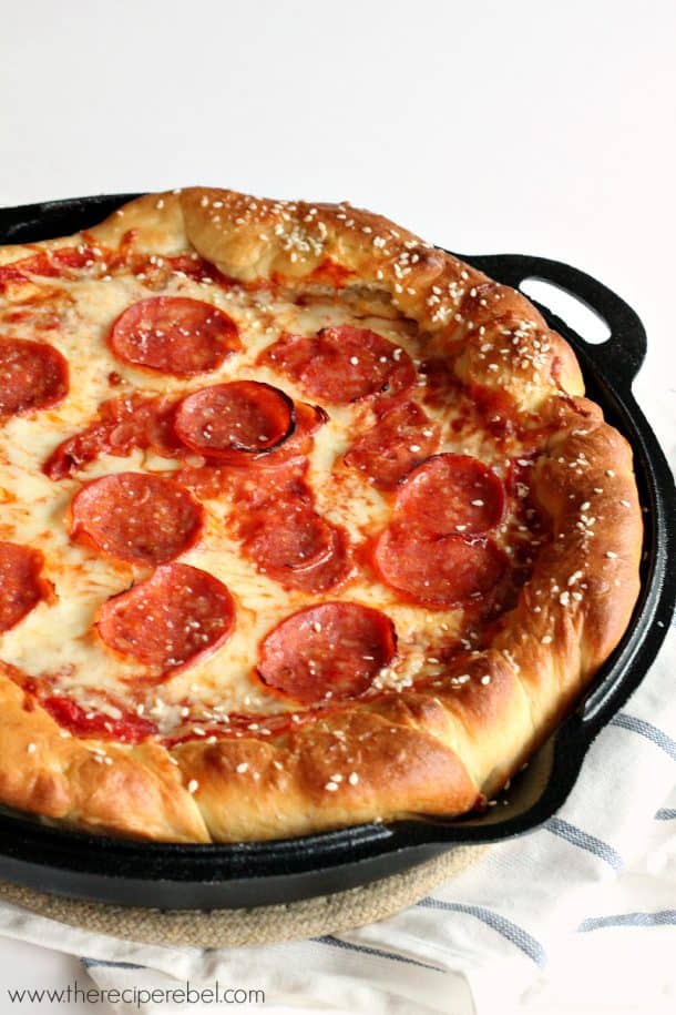 cast iron skillet with pretzel crust pepperoni pizza on white background