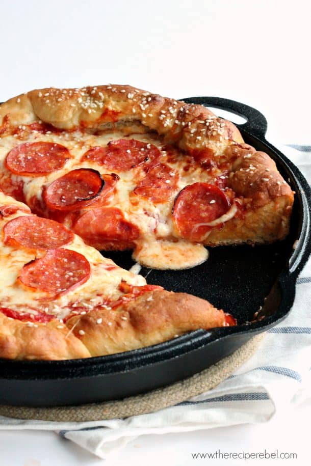 pretzel crust pizza in cast iron with one pizza cut out