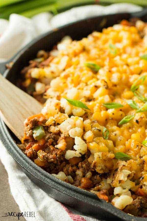 close up of wooden spoon scooping taco beef and potato skillet