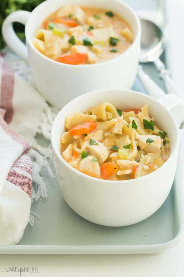 creamy chicken noodle soup in mugs close up