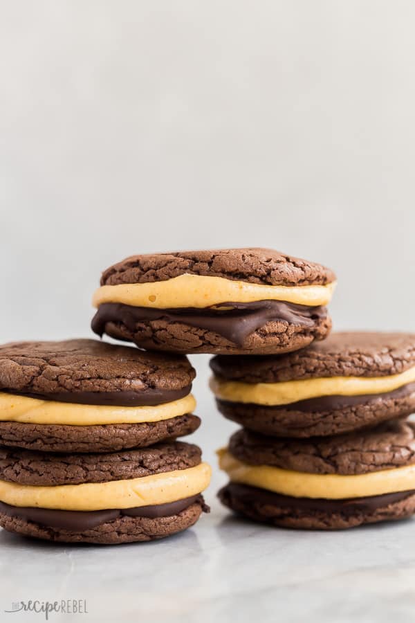 five pumpkin chocolate oreos stacked against white background