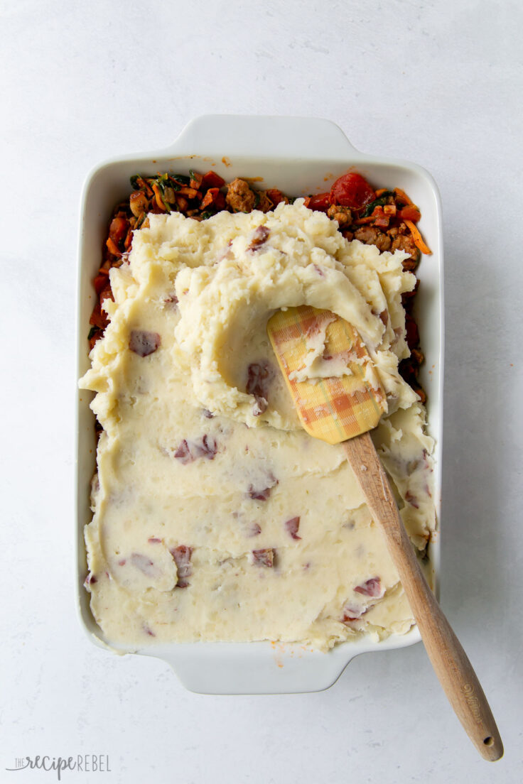 mashed potatoes being spread onto shepherds pie