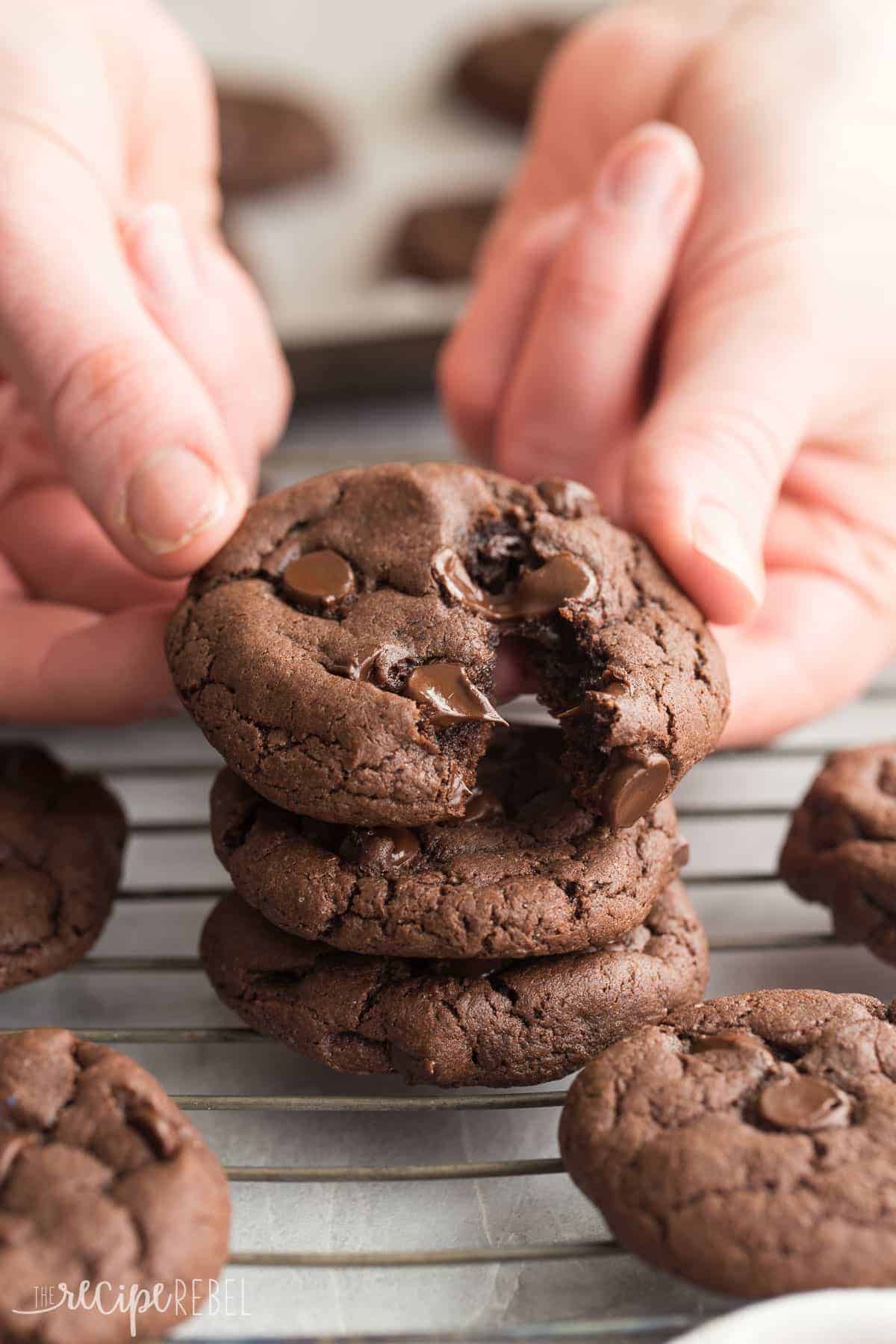 hands pulling apart chocolate cake mix cookie and melty chocolate chips in the middle