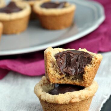 Fudge Puddles: super simple peanut butter cookie shells filled with a decadent chocolate truffle filling. www.thereciperebel.com