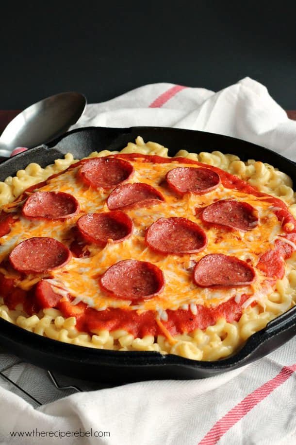 black skillet with pepperoni pizza mac and cheese on a white towel
