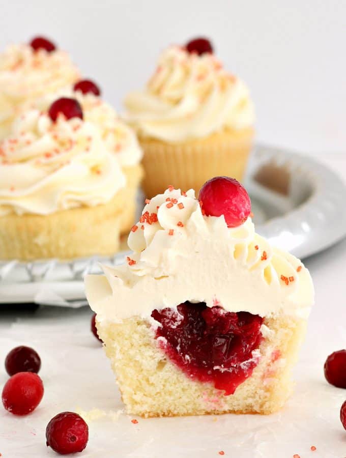 Cranberry Vanilla Cupcakes with White Chocolate Fosting: Perfectly sweet and fluffy vanilla cupcakes filled with sweet, tart cranberry filling and topped with a silky white chocolate buttercream -- perfect for the holidays! www.thereciperebel.com