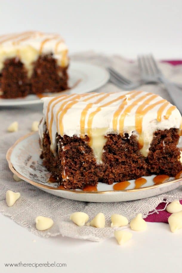 piece of gingerbread poke cake on plate with whipped cream and caramel sauce