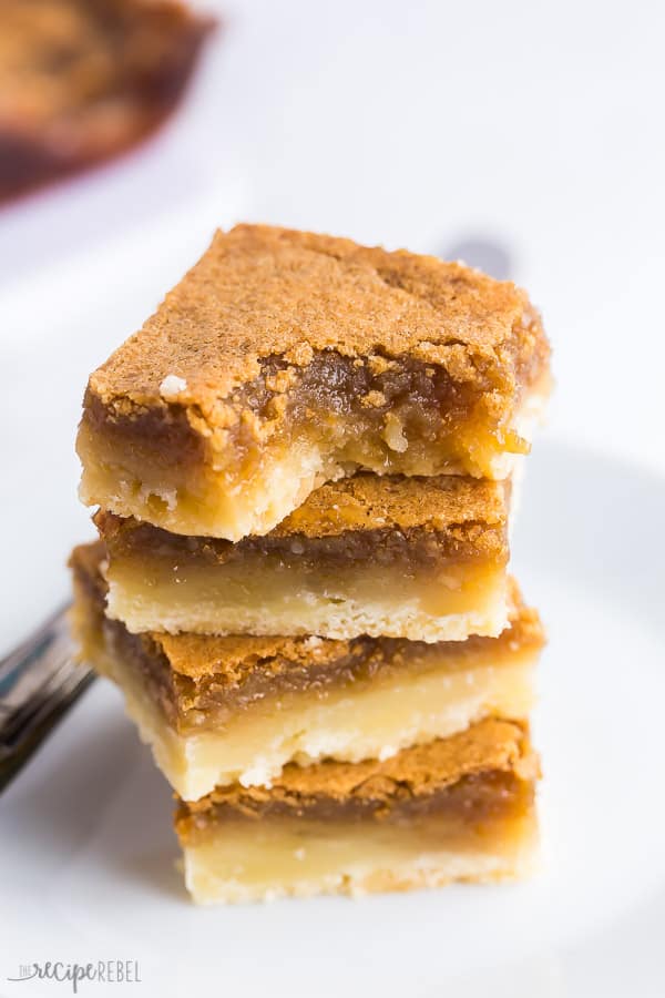 butter tart squares with bite stack of four on white background