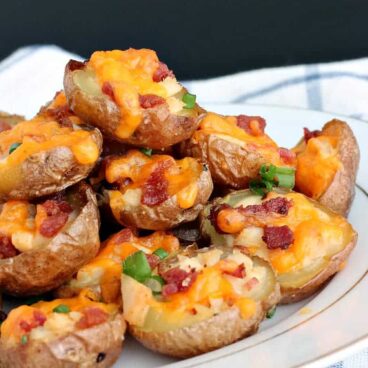 Chicken Bacon Alfredo Potato Skins: the perfect, poppable bites for your holiday entertaining! Creamy, cheesey, smoky bites that everyone will love. www.thereciperebel.com